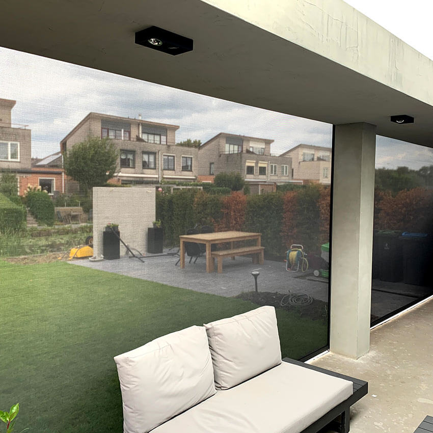 Uitzicht vanuit veranda door screens heen in Eemnes